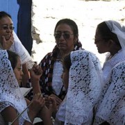 Hundreds of women line the streets and participate in their colorful shawls; young women, little girls, and grandmothers wear the white lacy veils that mark their devotion. (photo: Victoria Stone)