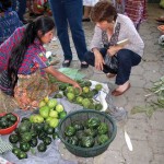 Alma with a woman selling güisquil at the back of the mercado