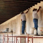 Trained stone masons, Augusto and Juan, work on the 1764 walls, injecting special mortar in the century-old plaster.