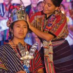 Sara Dalila Mux Mux, Rabin Ajau 2010-2011, lovingly places her crown on the new Daughter of the King, Rosa Lidia Auaré Castro. (photo by Thor Janson)