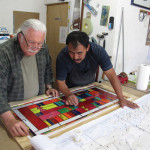 Lyn Hovey (left) checks the stained glass window with the printed plans