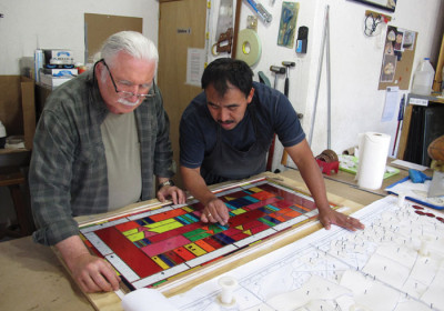 Lyn Hovey (left) checks the stained glass window with the printed plans