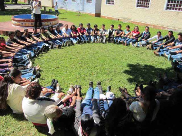 Chicos posando con las manos y los pies en el suelo en un círculo