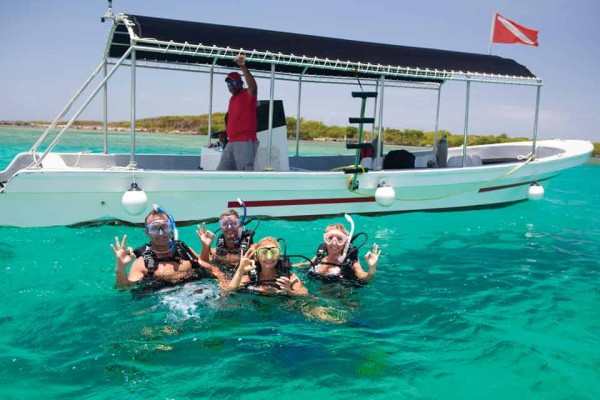 Four guys snorkelling on the reef of Roatan